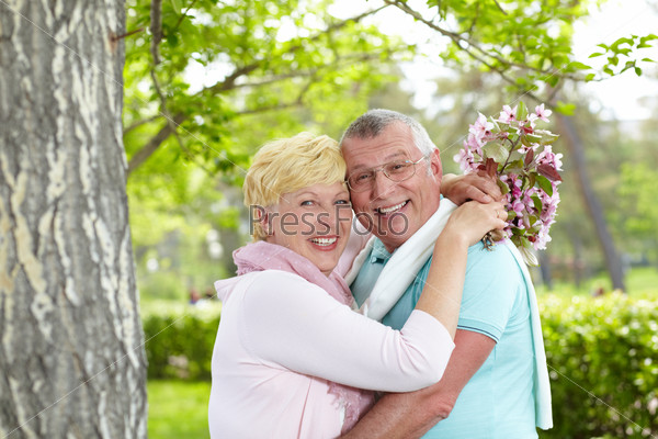 Happy mature couple embracing and laughing in the garden