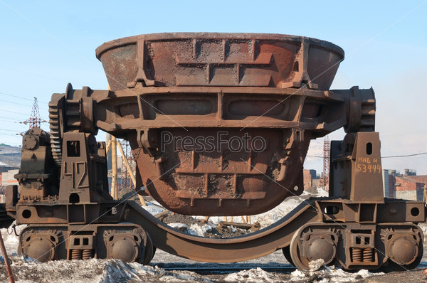 Steel buckets to transport the molten metal, mounted on railway platforms.