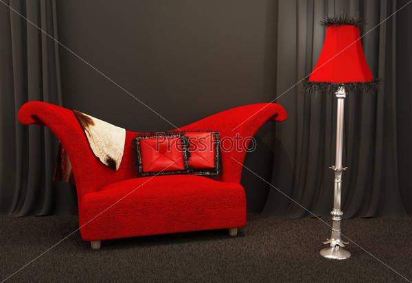 Red fabric sofa. Textured and curved sofa with standing lapm in a dark interior