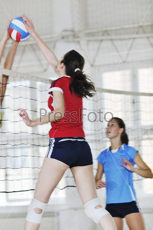 Volleyball game sport with group of young beautiful girls indoor in sport arena, stock photo
