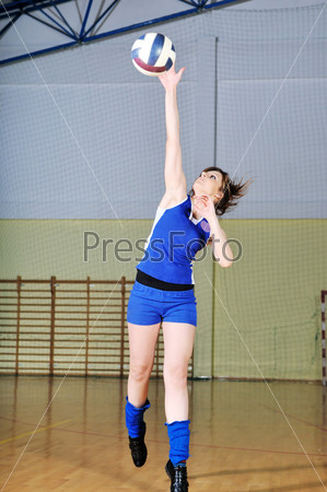 Девушка играет в волейбол в спортивном зале