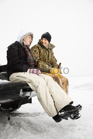 Young Couple Sitting on Truck Tailgate