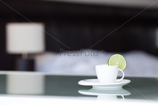 Tea with lemon on the background of the bed and the lamp, stock photo