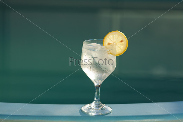 Swimming pool and a wine glass with ice and  lemon