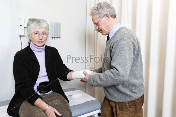 Пожилая женщина с повязкой на руке на приеме у терапевта