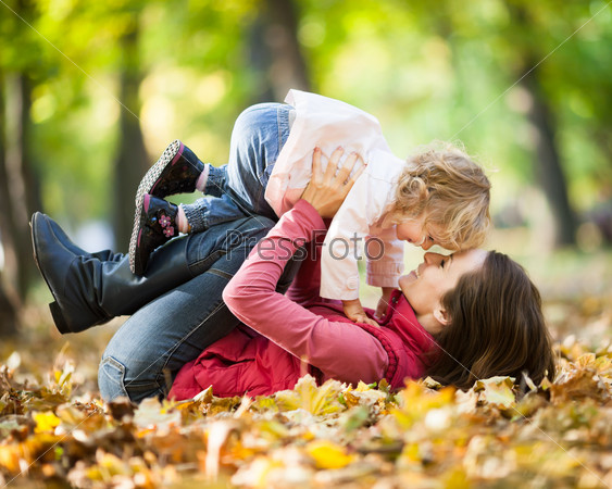 Woman with child having fun in autumn park