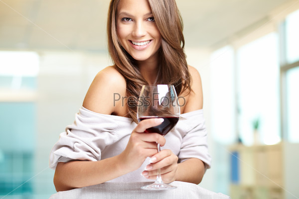 Portrait of a smiling young woman holding a glass of red wine