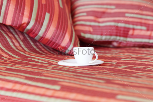 Bed with two pillows, a cup of tea on the blanket, stock photo