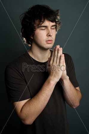 A young man praying alone