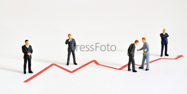Group of managers (model railroad figures) positioned around graph showing rising development.