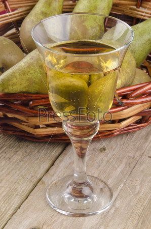 fruit wine in a glass and fresh pears in the background