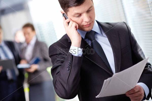 A handsome businessman calling by the phone in working environment