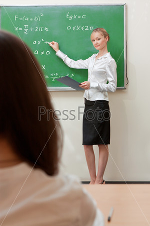 teacher writes on blackboard
