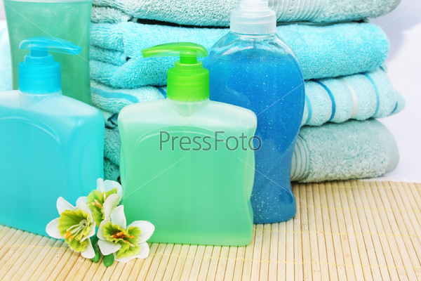 Towels, soaps and shampoo on bamboo mat.