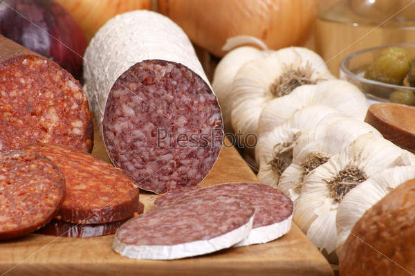 salami and some slices salami on a timber board