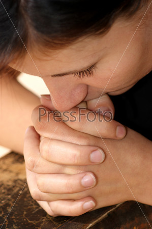 a young woman is praying in silence