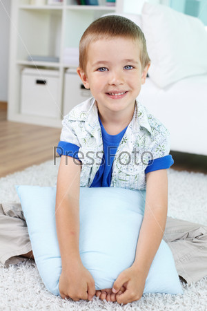Vertical shot of a little guy hugging the pillow