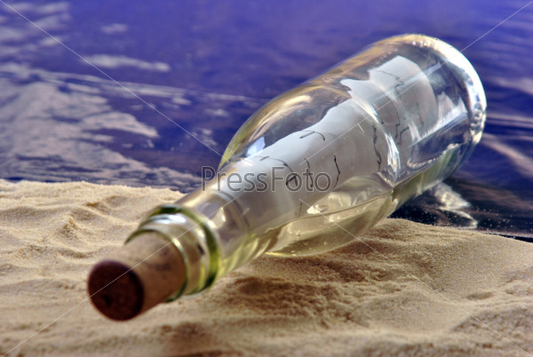 bottle message on a sandy beach with a letter