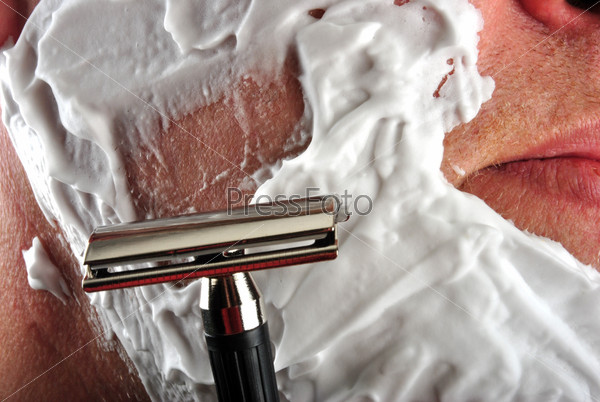 one wet shaving razor and some foam in a face