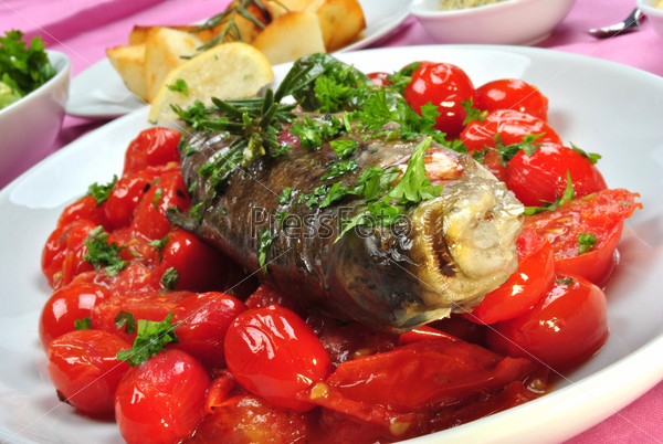 Grilled rainbow trout with organic tomato and parsley, stock photo
