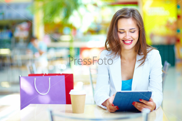 Shopping girl laughing looking at the screen of her portable device