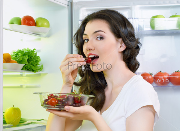 A hungry girl opens the fridge, stock photo