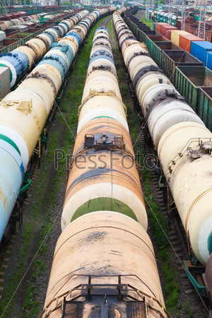 many oil tanks, containers and cars at the railroad station in bad weather
