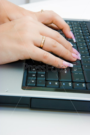 Women\'s hands with long nails on the laptop keyboard