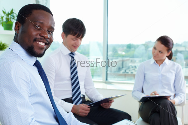 Portrait of successful boss looking at camera in working environment