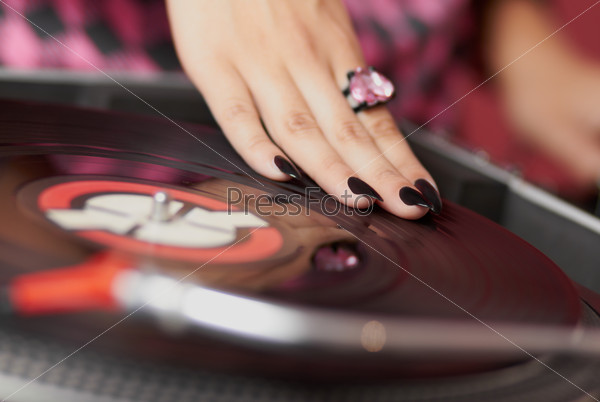Hands of female DJ mixing music