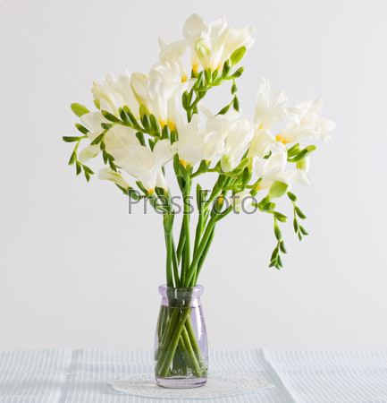 White freesia flowers in decorative bottles