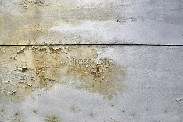 Peeling paint, mold growth and water stains on the ceiling of an abandoned house.