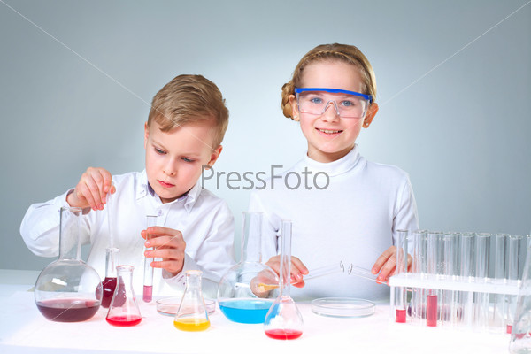 Lovely children doing homework experimenting with substances and samples