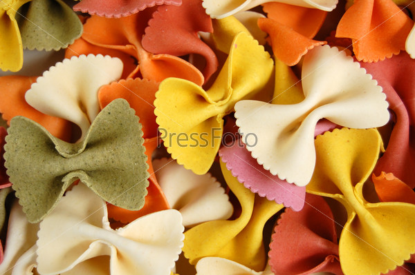 Many different flavors of fresh bow tie farfalle pasta. Italian food background.