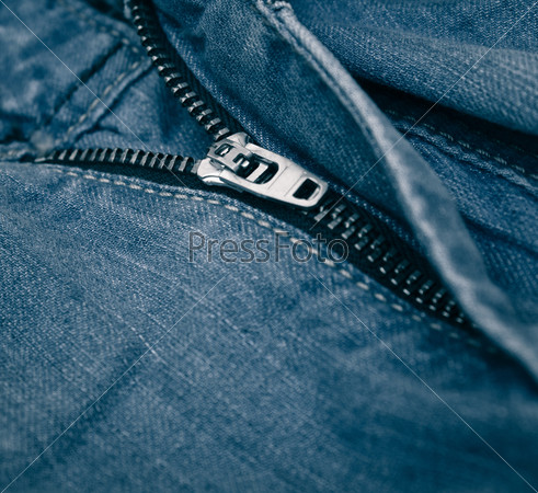 Denim fabric with a zipper on the crotch. The seams on the fabric.