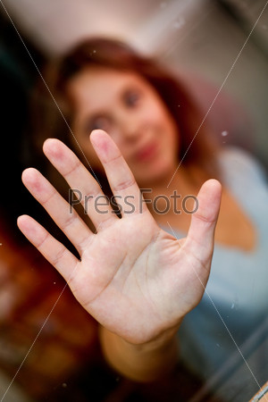 Lonely women with outstretched hand. In the glass.