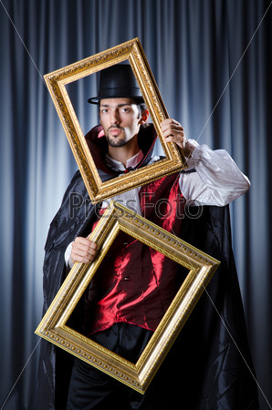 Magician with photoframe in studio