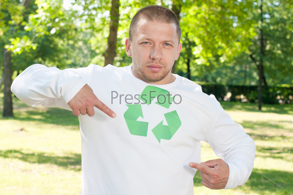 Эко-герой указывает на логотип переработки на футболке