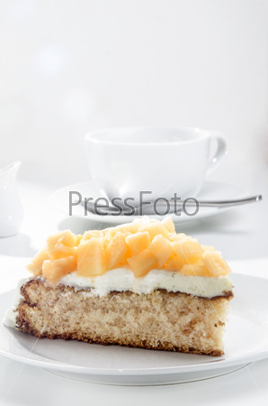 summer cake with diced honey melon on a white plate
