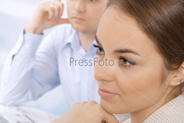 Closeup of a serious young business executive in a meeting with colleagues