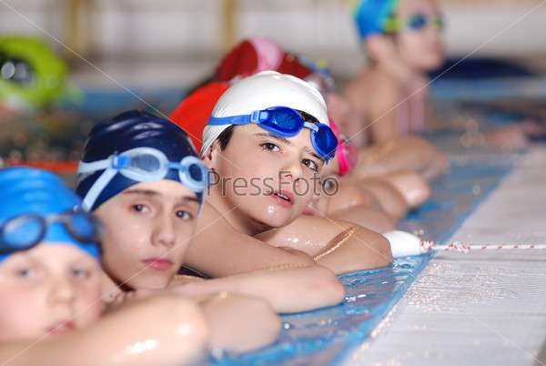 Счастливые дети на уроке плавания в бассейне