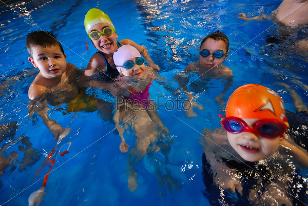 Счастливые дети на уроке плавания в бассейне