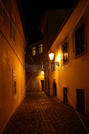 Narrow street in old town with luminous lanterns at night