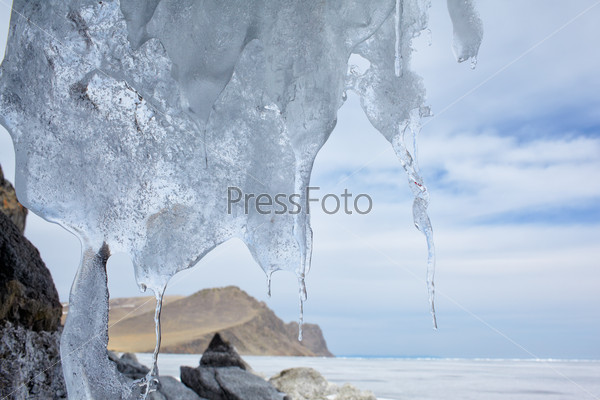 outdoor view of frozen baikal lake in winter with icicles on foreground