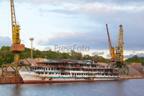 burned cruise liner in the port on the river Moscow in cloudy weather