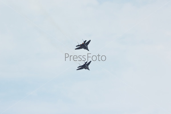 Two flying russian military jet fighter MiG-29 make attack in cloudy sky
