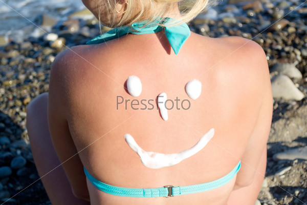 sun protection cream on her back