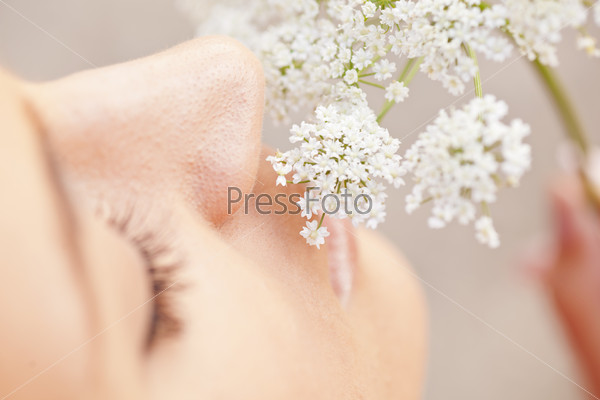 Woman smelling white flower
