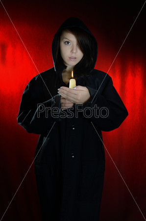 Young woman holding candle. On a dark blue background.