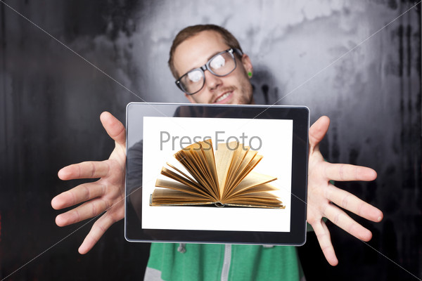 Young Nerd Smart Guy Man Using Tablet Computer with book on\
screen